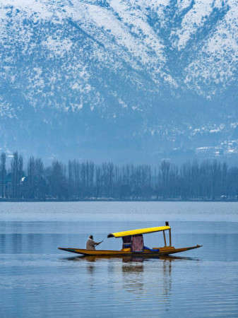 A view of Dal Lake in winter, and the beautiful snowcapped mountain range in the background in the city of Srinagar, Kashmir, India.